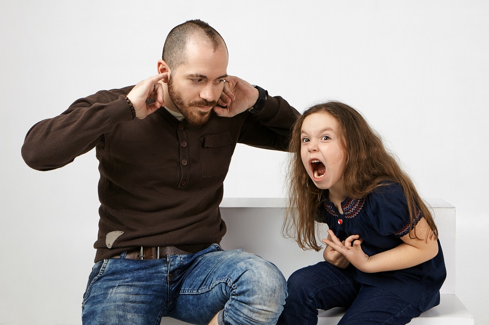 Angry little girl with long loose hair shouting, misbehaving bec